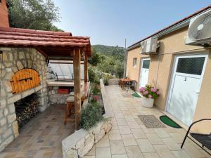 a patio with a stone fireplace and a table at Apartments LeviAna in Saplunara