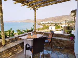a table and chairs on a balcony with a view of the ocean at Aegean Sunset in Kionia