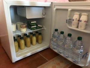 an open refrigerator with bottles of water and milk at Al dolce dormire in San Marco dei Cavoti