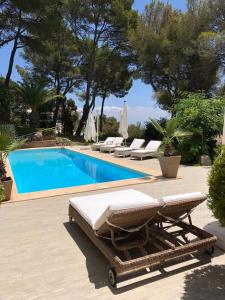 a swimming pool with two lounge chairs next to a swimming pool at Villa Es Pont, bis 10Pers, BBQ in Son Vida