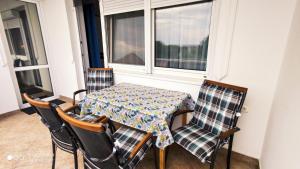 - une table et des chaises sur une terrasse couverte avec une fenêtre dans l'établissement Papp Apartmanház, à Vonyarcvashegy