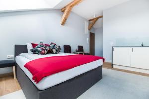a bedroom with a large bed with a red blanket at Dluga Apartments in Krakow