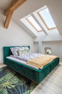 a bedroom with a large green bed with skylights at Dluga Apartments in Kraków