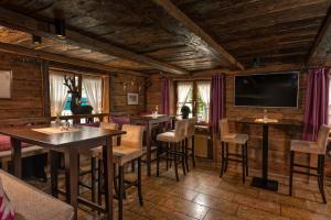 a restaurant with tables and chairs and a flat screen tv at Hotel Hirsch in Oberstaufen
