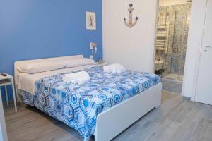 a blue bedroom with a bed with two towels on it at Il Pendio B&B in Bisceglie