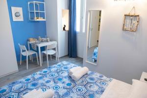 a blue and white bedroom with a bed and a table at Il Pendio B&B in Bisceglie