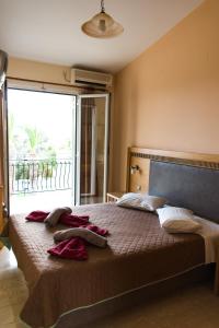 a bedroom with a large bed with red towels on it at Meraki apartments in Lassi