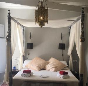 ein Schlafzimmer mit einem Himmelbett und zwei Kissen in der Unterkunft Boutique B&B Número Cuatro in Benissa