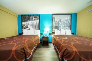 A bed or beds in a room at Super 8 by Wyndham Wichita Airport West Kellogg