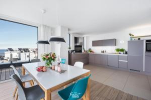 a kitchen and dining room with a table and chairs at Penthouse in Olpenitz