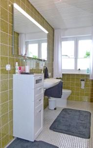 W łazience znajduje się umywalka, toaleta i lustro. w obiekcie Haus Tannenweg w mieście Zell an der Mosel