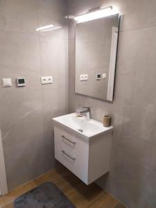 Baño blanco con lavabo y espejo en Garden & Pool apartment en Trnava