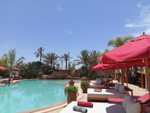a swimming pool with lounge chairs and umbrellas at Eden Lodges & SPA-Boutique Hôtel de Luxe in Marrakesh