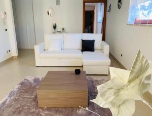 a living room with a white couch and a coffee table at Dimora Anvi - Relax Fronte Mare in Polignano a Mare