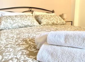 a bed with two pillows and two towels on it at Dimora Anvi - Relax Fronte Mare in Polignano a Mare