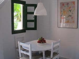 a white dining room table with a bowl of fruit on it at Puerto De Mogan Harbour 371 in Puerto de Mogán