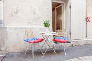 duas cadeiras e uma mesa em frente a um edifício em Le Cabanon du Vieux Port em Marselha