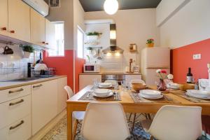 a kitchen with a wooden table and white chairs at Spacious Central Flat☆3min to Metro☆AC|Netflix|PC in Athens
