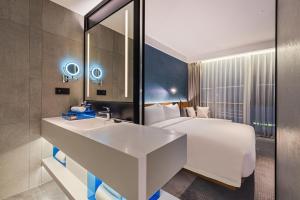 a hotel room with a bed and a sink at Novotel Dongguan Songshan in Dongguan