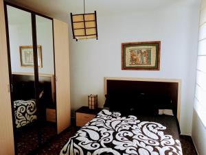 a bedroom with a black and white bed and a mirror at El atardecer de Cazorla in Cazorla