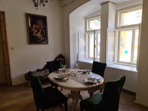 uma sala de jantar com mesa, cadeiras e janelas em Apartmány Svätá Barborka em Banská Štiavnica