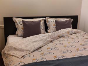 a bed with a blanket and pillows on it at Anties Namai in Juodkrantė