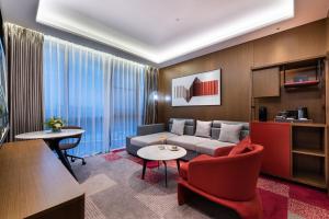 a living room with a couch and a table at Novotel Dongguan Songshan in Dongguan