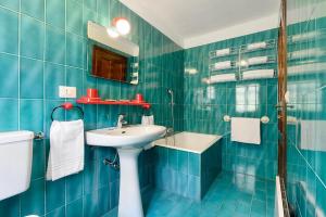 baño de azulejos azules con lavabo y aseo en Chalet Casa dei Nonni, en Ceppo Morelli