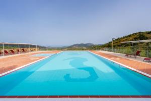 a large swimming pool with blue water at Hotel Is Murtas in Jerzu +18 photos