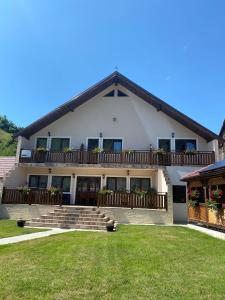 a large white house with a wooden balcony at CASA ALEXANDRA in Galeş