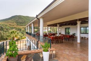 a restaurant with tables and chairs on a balcony at Hotel Is Murtas in Jerzu