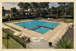 a large swimming pool with people sitting around it at Secret Spot Apartment - Quinta da Barca in Esposende