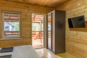 a room with a bed and a television and a balcony at Sonyachni bungalo in Melʼniki