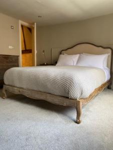 a bed with a wooden frame in a bedroom at The Woolpack Hotel in Tenterden