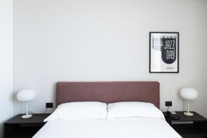 a bedroom with a bed with two lamps and a poster at Hotel Punta Tipa in Trapani