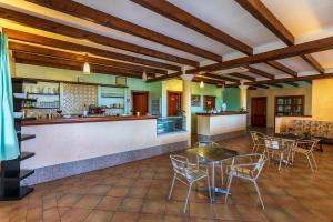 a restaurant with tables and chairs and a bar at Hotel Is Murtas in Jerzu