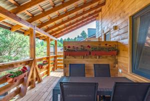 a wooden patio with a table and chairs on a deck at Sonyachni bungalo in Melʼniki