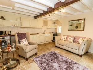 a living room with two chairs and a couch and a table at Chapel Cottage in Redcar