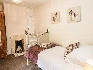a bedroom with a bed and a fireplace at Chapel Cottage in Redcar