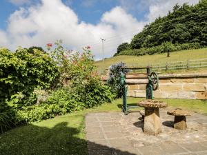 a bench in a garden with a hill in the background at Chapel Cottage in Redcar