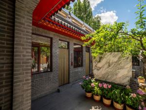 Dong Li Guest House في Miyun: مبنى أمامه نباتات الفخار