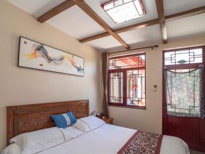 a bedroom with a bed and two windows at Dong Li Guest House in Miyun