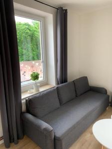 un sofá en una habitación con ventana en Apartmány LUXOR, en Česká Lípa