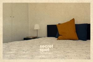 a bed with a orange pillow on top of it at Secret Spot Apartment - Quinta da Barca in Esposende +58 photos