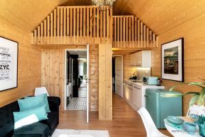 a kitchen and living room in a log cabin at Trzy Domki w Mielnie in Mielno