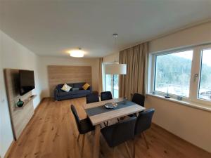 a living room with a table and chairs and a couch at Gleiming apartments in Schladming