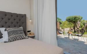 um quarto com uma cama e vista para um pátio em Eptanisos Beachfront Suites Zante em Kerion