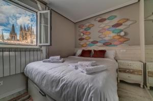 a bedroom with a bed with towels on it at Iraipe Burgos Centro Apartamentos in Burgos