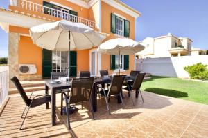 a patio with a table and two umbrellas at Villa Rosa - with private pool in Alcantarilha
