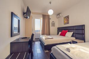 Habitación de hotel con 2 camas y escritorio en Apartments Atlantis, en Dobra Voda